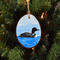 A handmade Christmas ornament with a hand-painted common loon and blue background available at Cove Creek Photography.